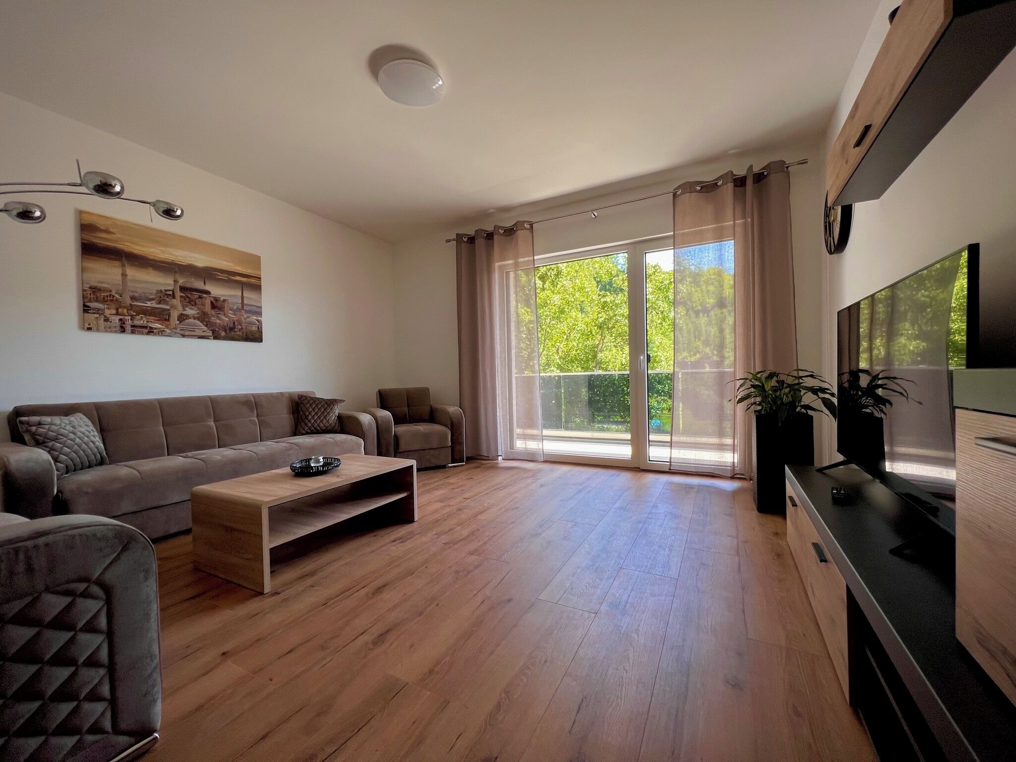 Un salon moderne avec un canapé, une table basse et un téléviseur.