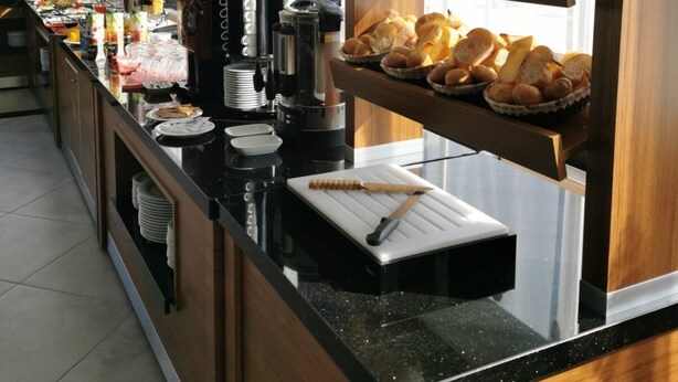 A buffet counter with various food items and a coffee machine. - Golden Rose Deluxe Hotel (Manisa)