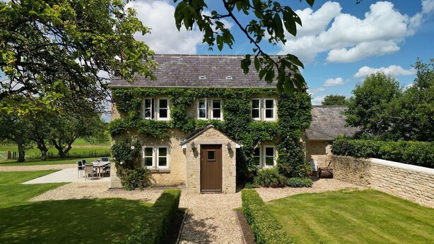 A stone house with a central entrance, surrounded by a well-maintained lawn and garden. - Otmoor House - Beckley, Near Oxford (Beckley)
