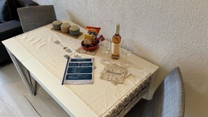 Une table dressée avec un menu, une bouteille de vin, des amuse-gueules et une pancarte « Bienvenue ».