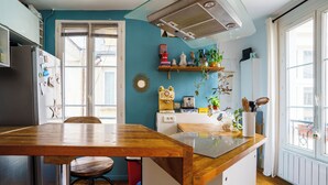 Cucina con isola in legno, frigorifero e diversi elettrodomestici.
