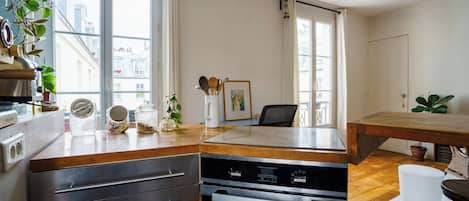 A modern kitchen with a dishwasher, oven, and wooden countertop.
