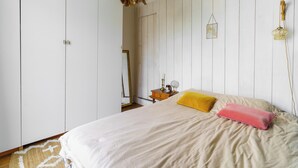 Una camera da letto con un letto, un comodino, uno specchio e un armadio.