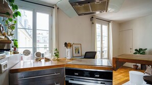 Una cucina moderna con forno integrato, un piano di lavoro in legno e un'area pranzo con tavolo e sedie.