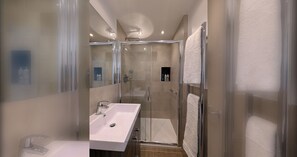 A modern bathroom with a glass-enclosed shower, a white sink, and a towel rack. - Thames Riverside Retreat: A Serene 3-Bed Bungalow (Surrey)