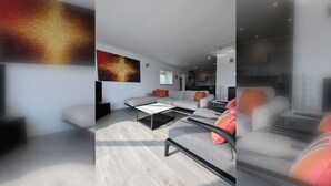 A modern living room with a sofa, coffee table, and a TV.
