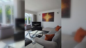 A modern living room with a sofa, coffee table, and a flat-screen TV.