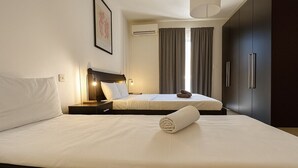 A hotel room with two beds, a nightstand with a lamp, a wardrobe, and a framed picture on the wall. - Private BBQ + outdoor + fun area St. Julians (St Julians)