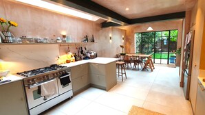 Una cocina moderna con una isla central, horno empotrado y comedor con vista al jardín.