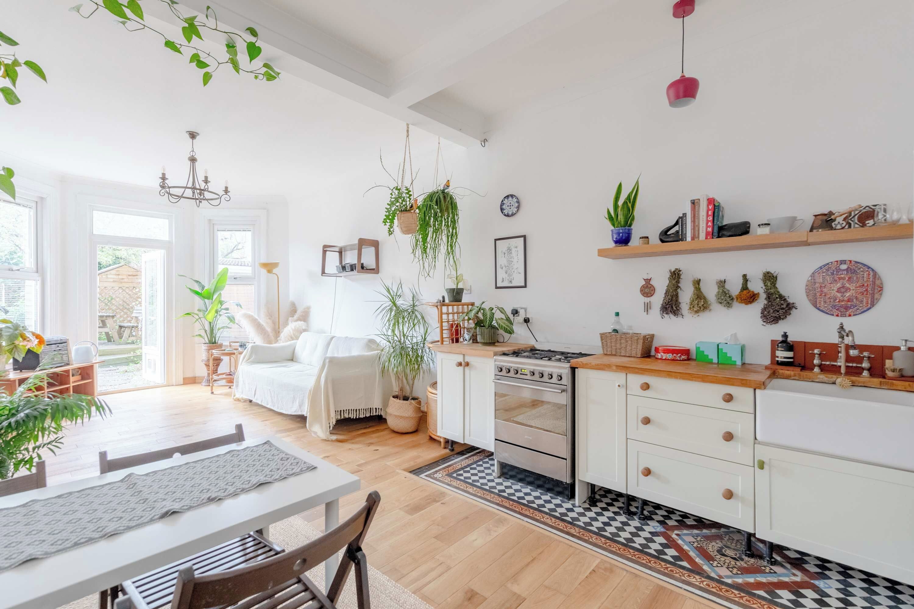 A bright kitchen with wooden cabinets, a stove, and a dining area with a table and chairs.