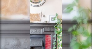 A fireplace with decorative moldings and a red brick surround. - Modern Farmhouse-Style 1BD Flat - Wood Green! (Greater London)