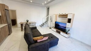 A modern living room with a sectional sofa, a flat-screen TV, and a dining area with a table and chairs. - St.Julian's Brand New apartments (1)

Walking distance to St Julians Paceville

 (Swieqi)