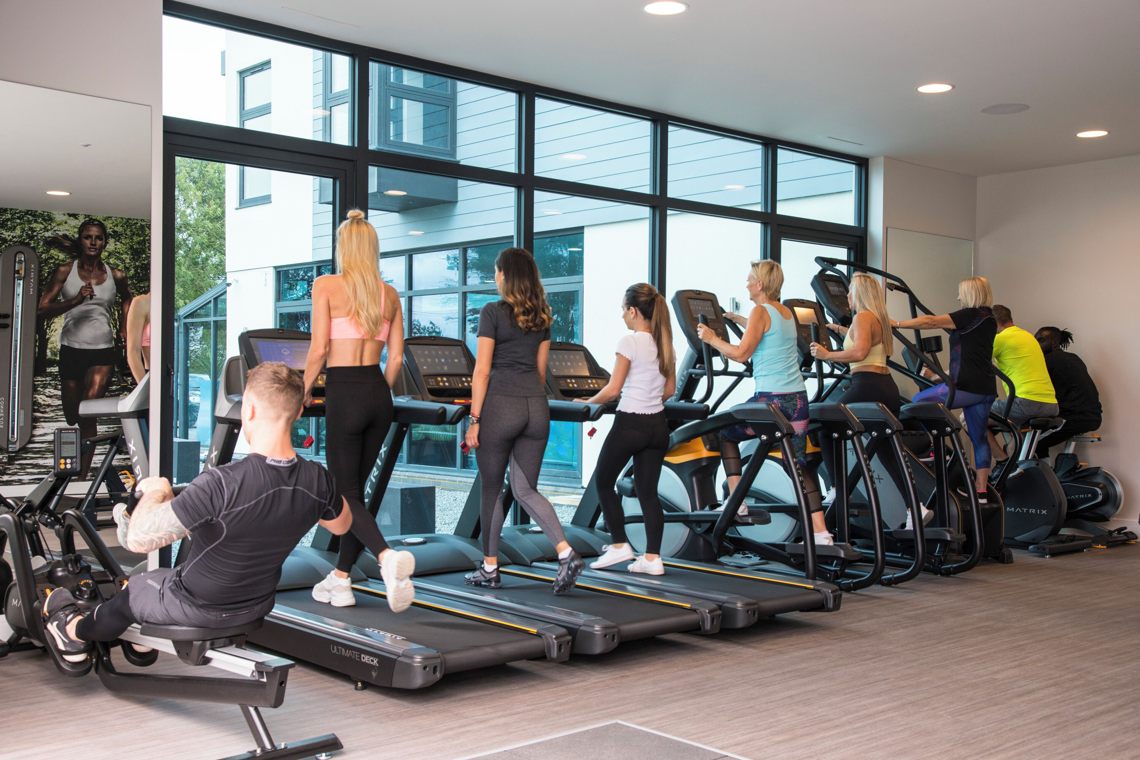 Un gimnasio con cintas de correr y equipo de ejercicio.