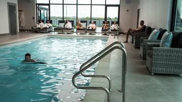 Indoor pool, open 8:00 AM to 7:00 PM, pool umbrellas, pool loungers