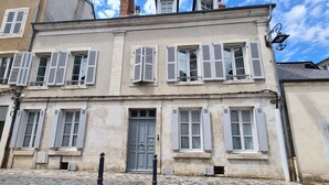 A historic building with a symmetrical facade, large windows with shutters, and a central door. - Spacieuse Chambre avec Lit King-Size, Salle d'Eau Privative et Petit-Déjeuner Inclus (Châteauroux)