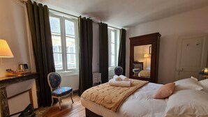 A hotel room with a bed, a chair, a desk, and a window with curtains. - Cozy Room "Pondichéry" with Private Bath and Breakfast Included in Châteauroux House (Châteauroux)