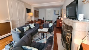 A living room with a sectional sofa, a fireplace, a television, and a dining area with a table and chairs. - Cozy Room "Pondichéry" with Private Bath and Breakfast Included in Châteauroux House (Châteauroux)