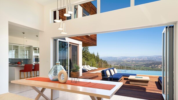 Un espacio habitable moderno con comedor, cocina y terraza con vistas al paisaje.