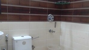 A bathroom with a toilet, a shower, and a sink. - Corporate Stay (Gurugram)