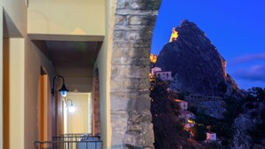 A corridor with a stone column, a railing, and a view of a mountain at dusk. - La Locanda di Castromediano (Castelmezzano)