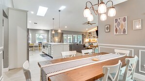 A spacious kitchen with a central island, white cabinetry, and pendant lighting. - Screened Lanai + Fenced Yard: Luxe Orlando Home (Orlando)