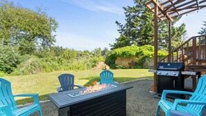 An outdoor patio with a grill, chairs, and a fire feature. - 1/2 Mi to Ocean: Copalis Beach Hideaway! (Copalis Beach)