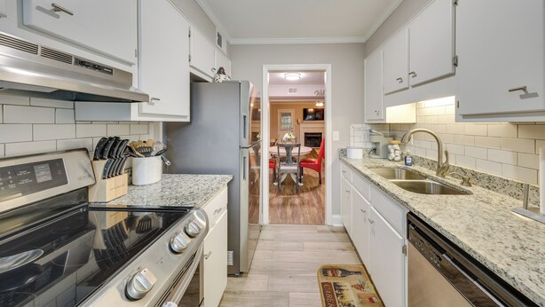 A modern kitchen with white cabinets, a stainless steel range, a dishwasher, and a granite countertop. - Quaint Augusta Townhome: 3 Mi to the Masters! (Augusta)