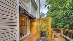 A wooden deck with a covered seating area and a wooden fence with climbing plants. - Quaint Augusta Townhome: 3 Mi to the Masters! (Augusta)
