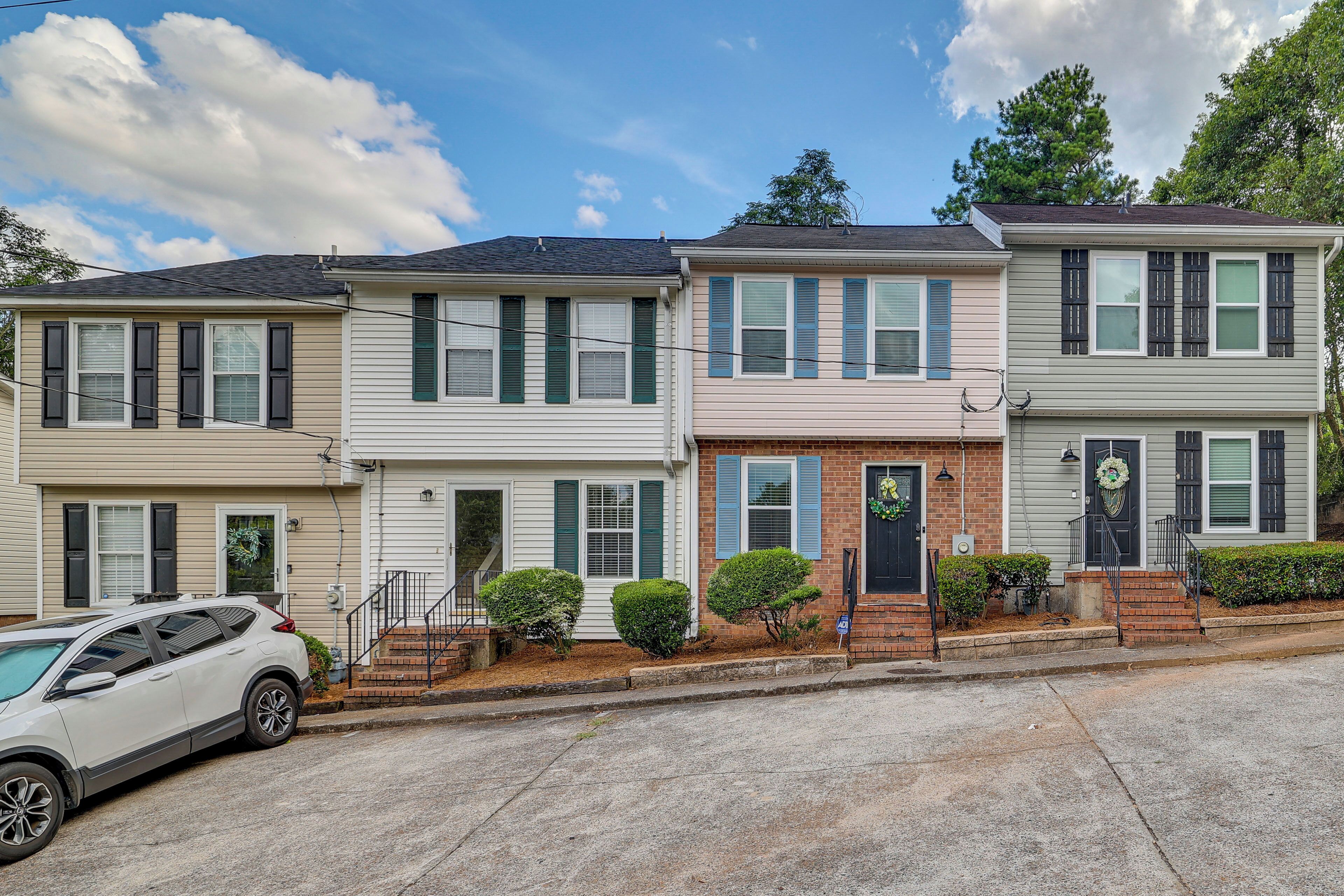A row of townhouses with a car parked in front.