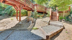 A wooden bridge with a staircase leading up to it, surrounded by gravel and greenery. - 1 Mi to Lake: Crestline Cabin w/ Deck + Gas Grill! (Crestline)
