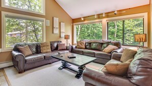 A spacious living room with a sectional sofa, large windows, and a modern coffee table. - 1 Mi to Loon Mountain: Lincoln Haven w/ Balcony (Lincoln)
