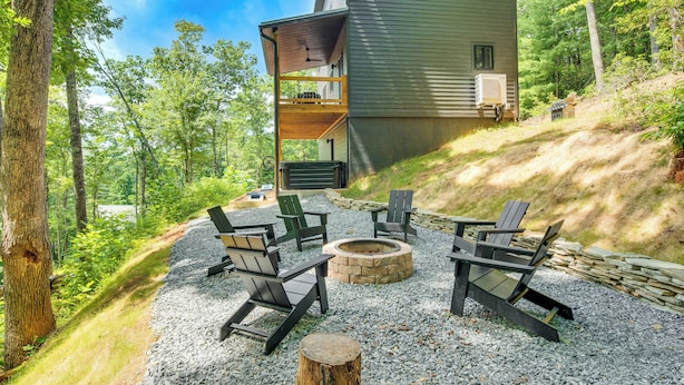 Eine Hütte mit einer Terrasse, Sitzgelegenheiten im Freien und einer Feuerstelle.