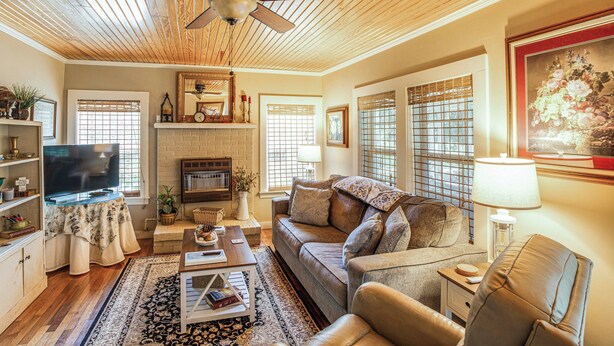 A cozy living room with a fireplace, comfortable seating, and a television. - Charming Country Home w/ Yard - 14 Mi to Ole Miss! (Oxford)