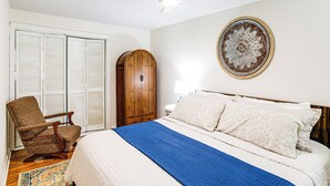 A bedroom with a bed, a wooden chair, a wardrobe, and a ceiling fan. - Charming Country Home w/ Yard - 14 Mi to Ole Miss! (Oxford)