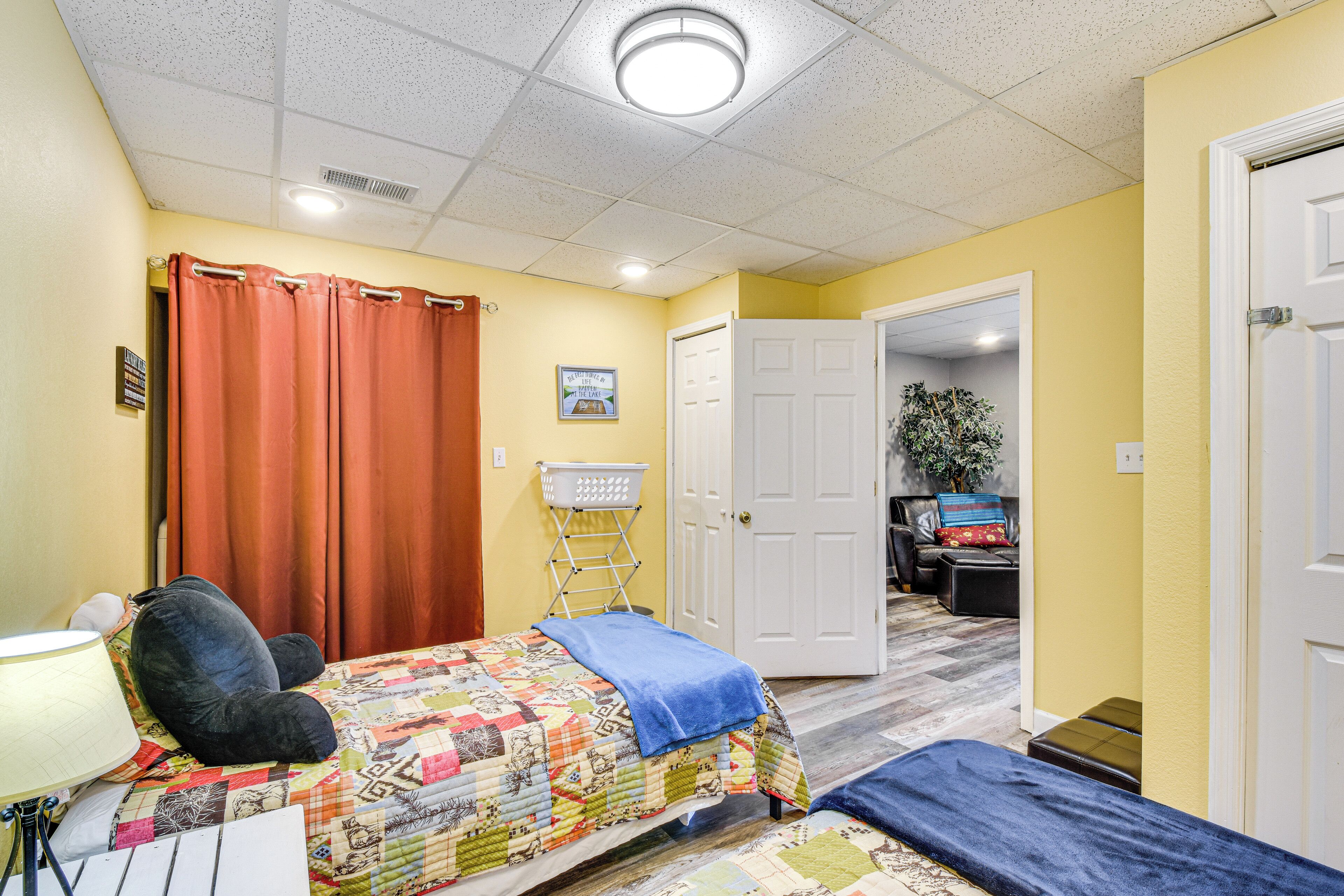 Een slaapkamer met een bed, een stoel, een bureau en een deur naar een andere kamer.