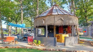 A rustic gazebo with a thatched roof, surrounded by trees and a small seating area with benches. - Pet-friendly Grand Lake Studio w/ Outdoor Space (Grove)