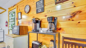 A kitchen area with wooden walls, a clock, a coffee maker, a toaster, and a refrigerator. - Inlet Lakefront Home: Private Dock & Beach Access! (Inlet)