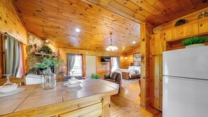 Ein Holzblockhaus mit Küche, Essbereich und Wohnzimmer.