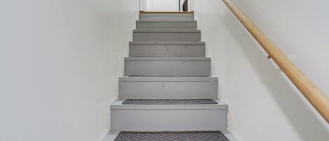 A staircase with a handrail and a door at the top.