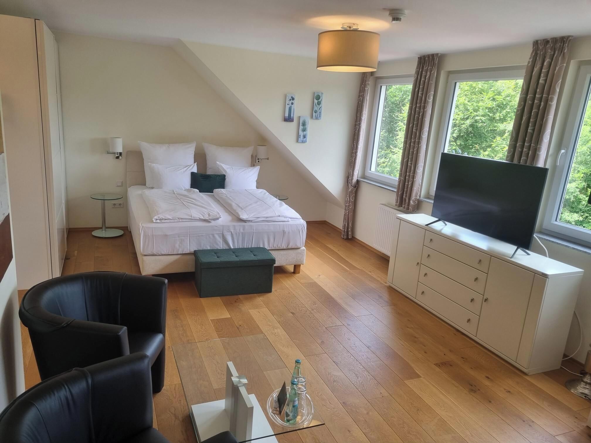 A bedroom with a bed, a TV, a desk, and a chair.