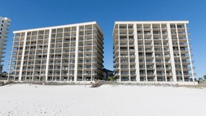 A beachfront hotel with multiple floors, balconies, and a clear sky. - The Palms 714 by Liquid Life (Orange Beach)