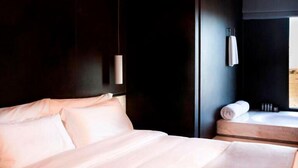A hotel room with a large bed, a bedside table, a window, and a bathroom visible through the door. - Al Faya Retreat by Sharjah Collection (Al Madam)