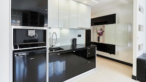 A modern kitchen with black countertops, white cabinets, and a built-in oven. - Villa Park by Baltic Home (Swinoujscie)