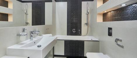 Un baño moderno con dos lavamanos, una bañera y un inodoro.
