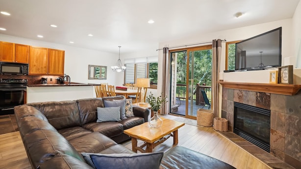 Una sala de estar moderna con un sofá de cuero, una mesa de centro de madera y una chimenea.