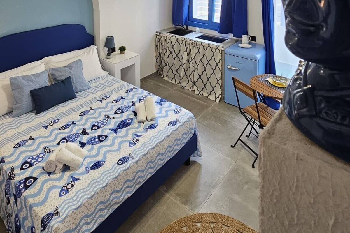 A bedroom with a bed, a desk, and a chair.