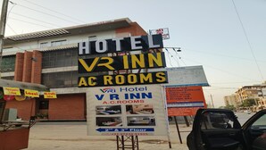Une enseigne d’hôtel faisant la publicité de l’établissement VR Inn A.C. Rooms, indiquant que les chambres se trouvent aux deuxième et troisième étages.