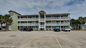 A multi-story hotel with a central entrance and balconies. - Kontiki Beach Resort #317 | Canal-Front View + Pool Access! (Rockport)