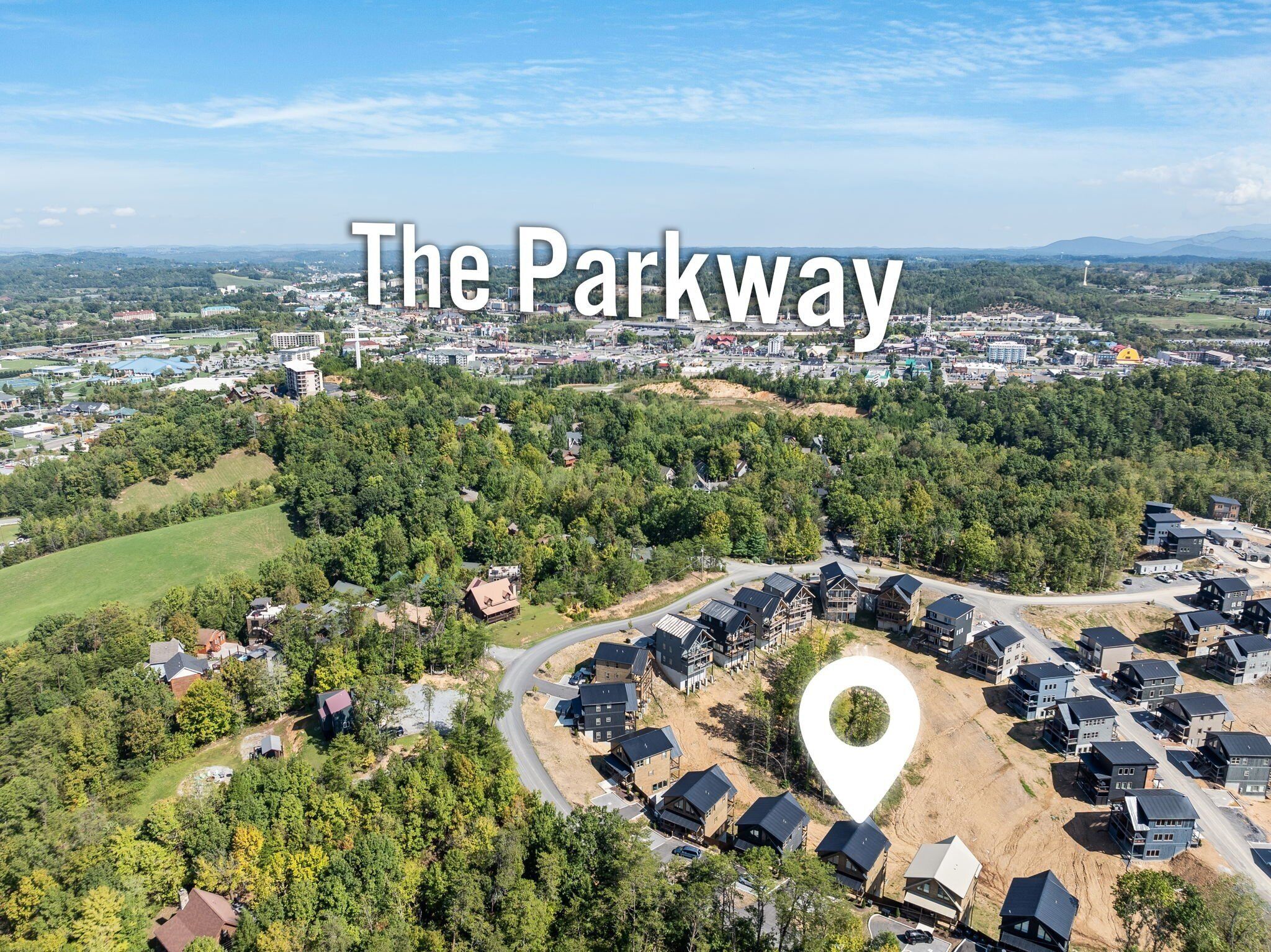 Vista aerea di Parkway, con edifici residenziali, aree verdi e una strada principale.