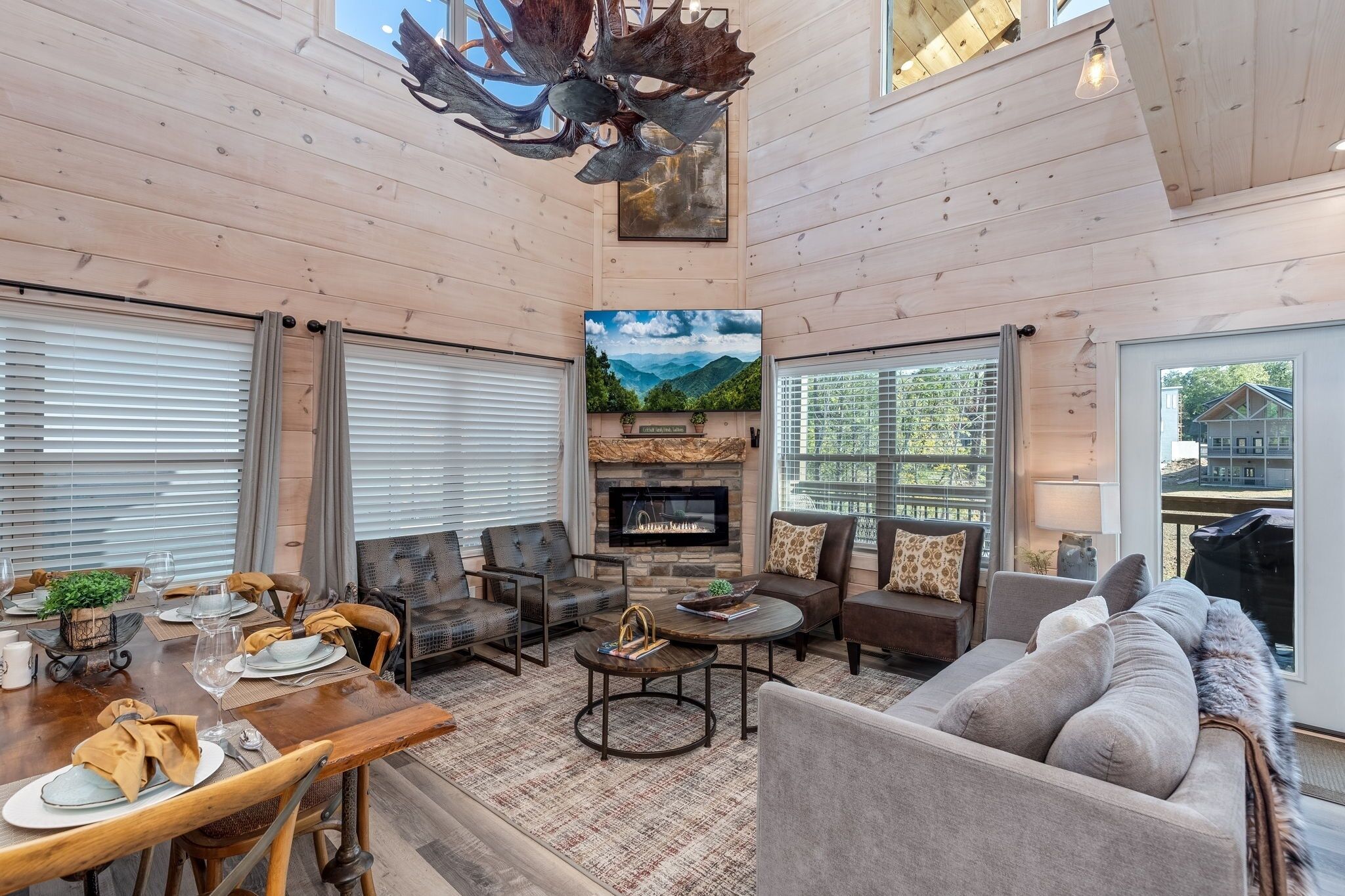Un salón amplio con chimenea, asientos cómodos y ventanas grandes.